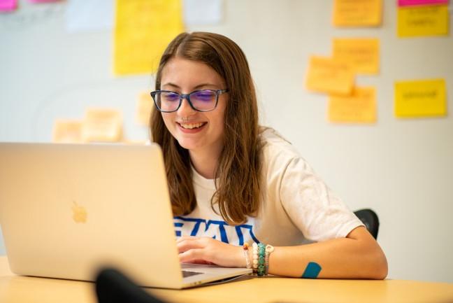 An online student sitting at their laptop