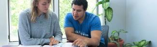 two students studying out of a shared book