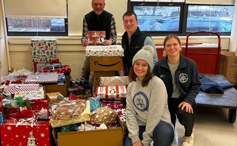 Members of UNE's Pediatrics Club and Sigma Sigma Phi pose with a variety of wrapped presents they plan to donate